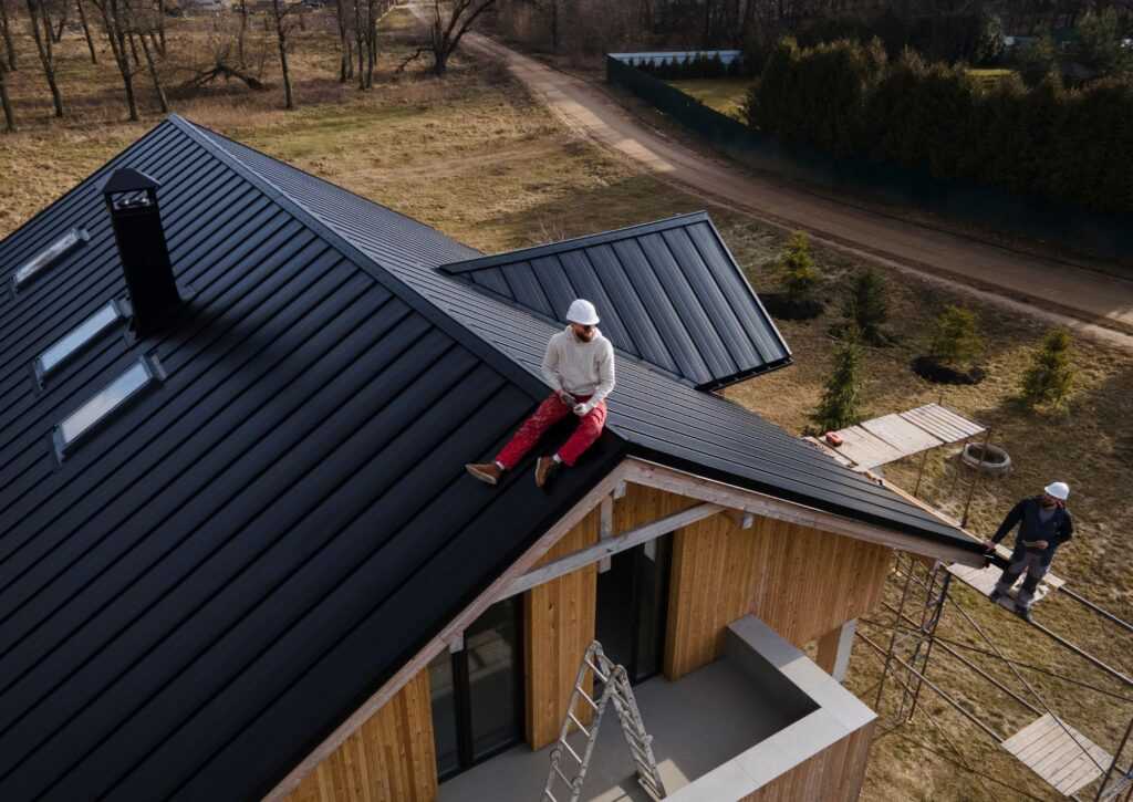Mężczyzna w kasku siedzący na dachu widok z góry